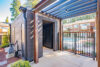 Modern wooden utility building with package lockers, Pergola-covered entrance with metal railings overlooking a pool area